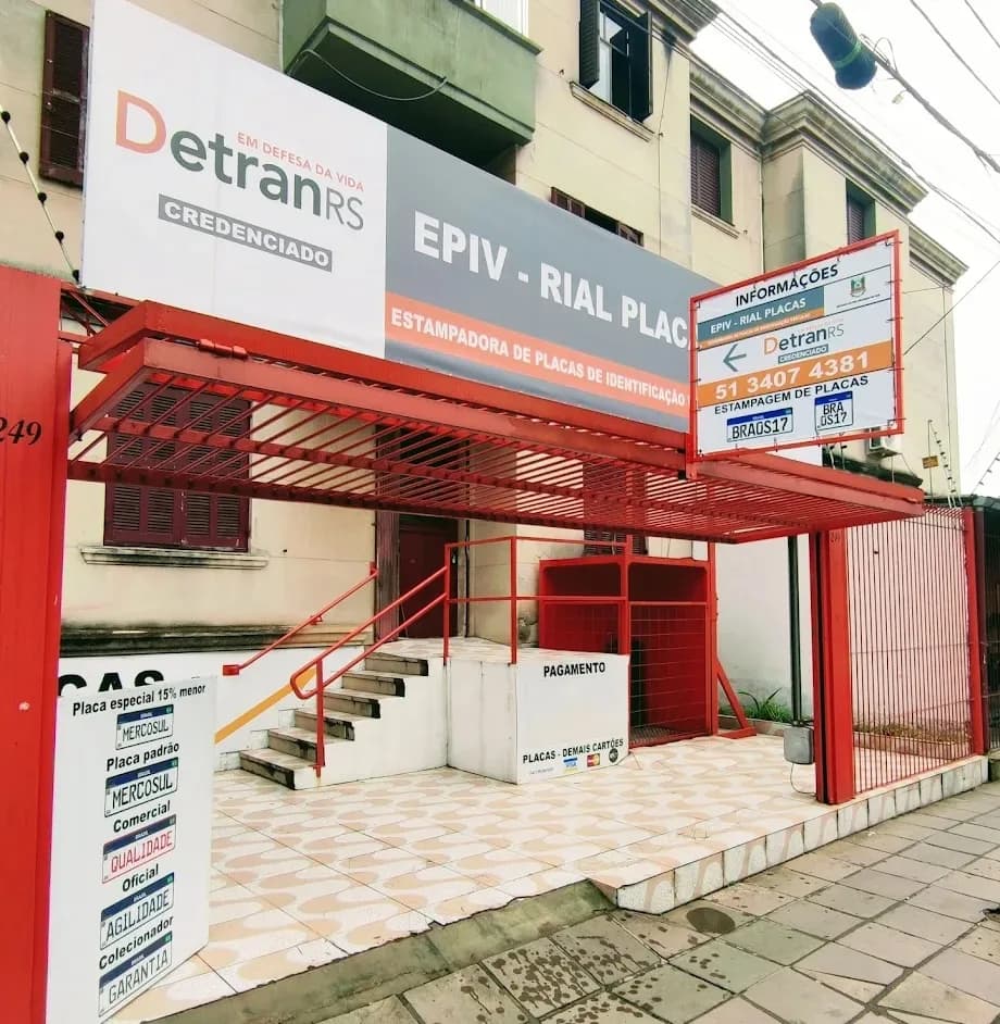 Fachada da Rial Placas na R. Comendador Coruja, 249, bairro Floresta, em Porto Alegre, com o letreiro DetranRS Credenciado e EPIV, Rial Placas, Estampadora de Placas de Identificação